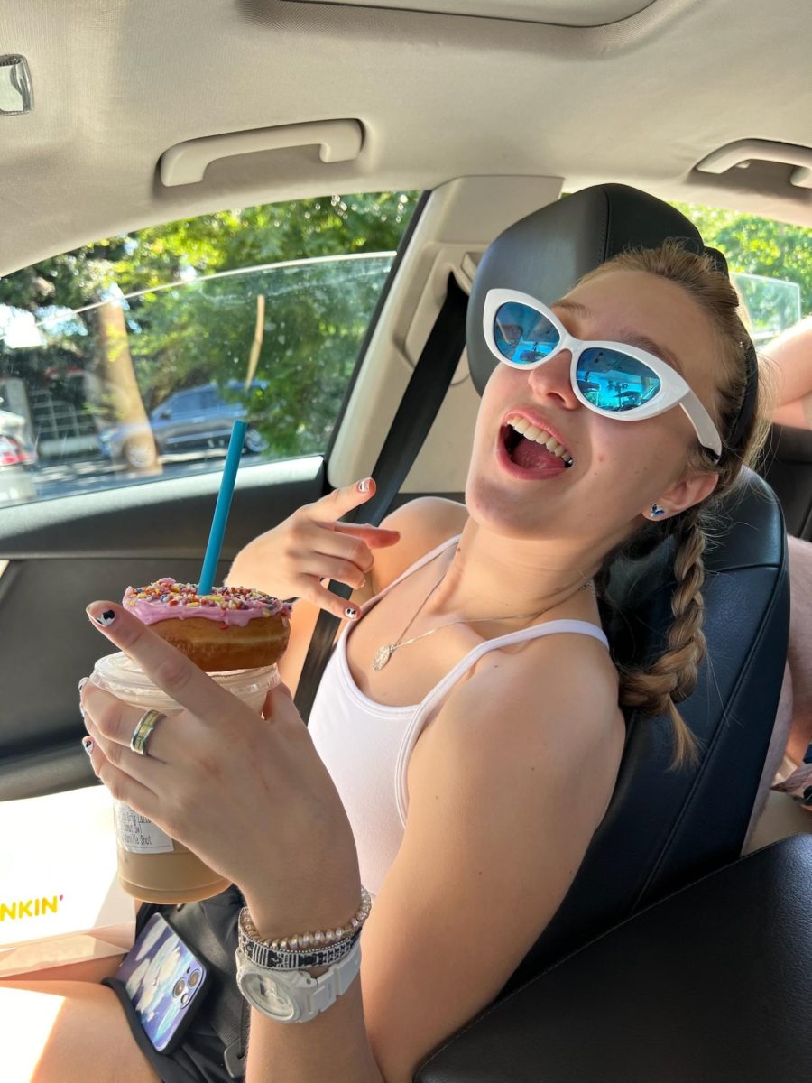 Photo of CJ Greenway holding a donut and coffee.